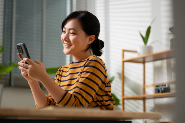 istock Asian woman happy enjoy using smart phone at home office. 1434883062