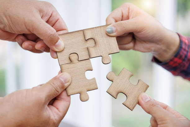 istock Group of business people assembling jigsaw puzzle and represent team support and help concept 1434884336