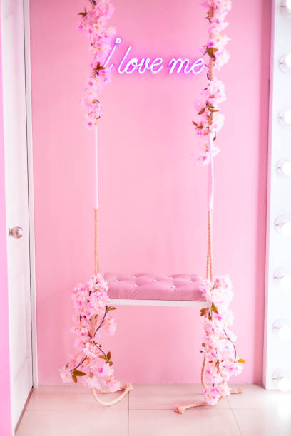 Swing with flowers on pink background