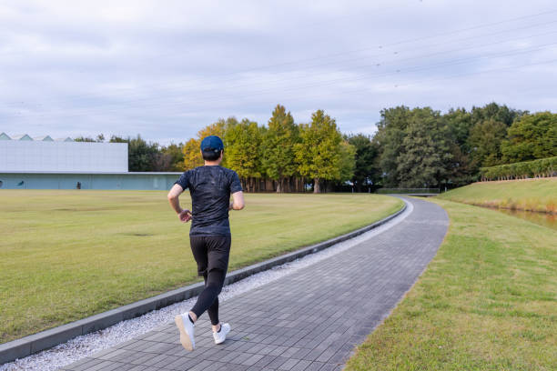 jeune japonais faisant du jogging dans le parc - base runner photos et images de collection