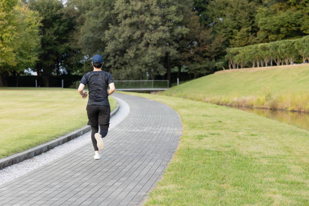istock Young Japanese man jogging in the park 1434890624