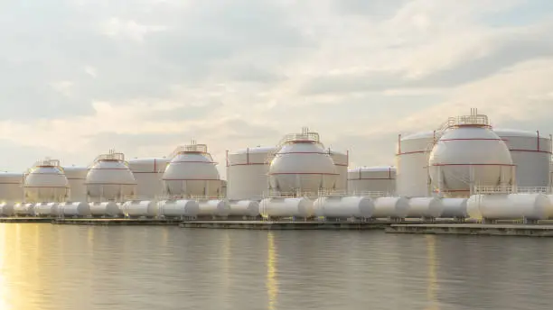 Photo of Gas Storage Tanks On Sea Coast At Sunset