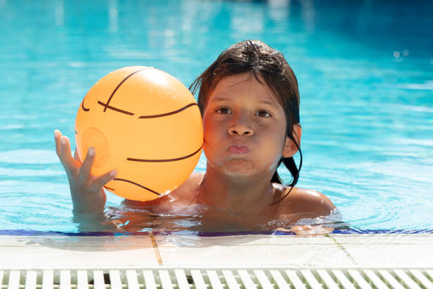 istock Cute Young Boy Fun in the Swimming Pool with Goggles 1434908574