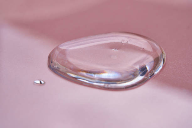 A drop of cosmetics or perfume on a pink background.