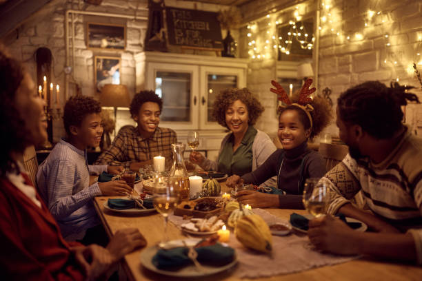 istock Happy black extended family talking at dining table while celebrating Thanksgiving together. 1434915444