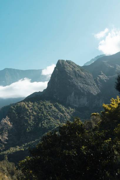 istock Lovely vertical shot of gorgeous mountains with bright white clouds circling around them 1434916436
