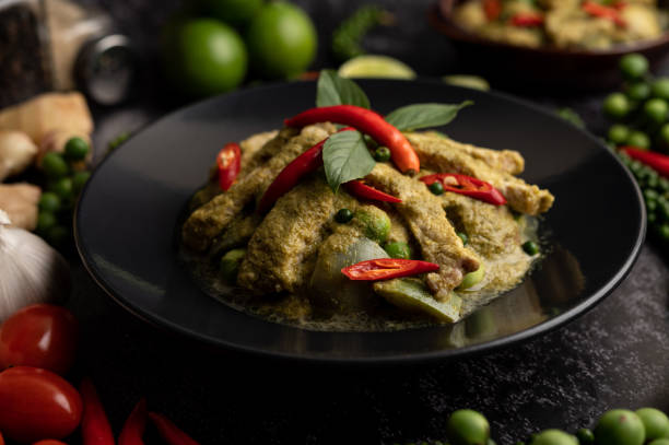 istock Pork green curry in black plate with spices on black cement background 1434917144