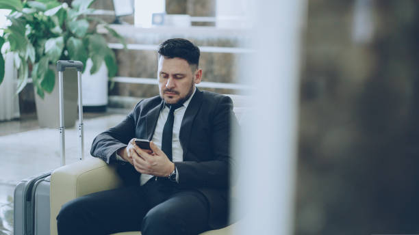 istock Bearded concentrated businessman using smartphone sit on armchair inside luxury hotel after arrivel to business meeting 1434917249