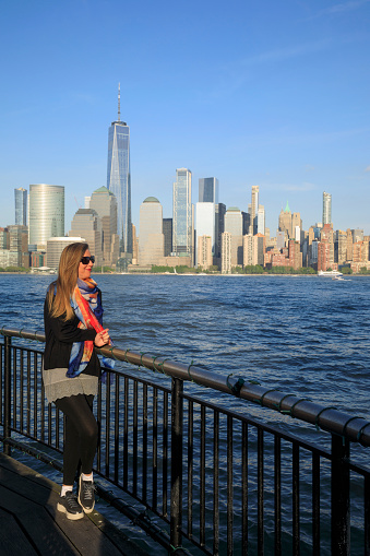 Pretty  active women Long blonde hair enjoying  in  Panorama of New York City skyline Lower Manhattan and the Freedom Tower