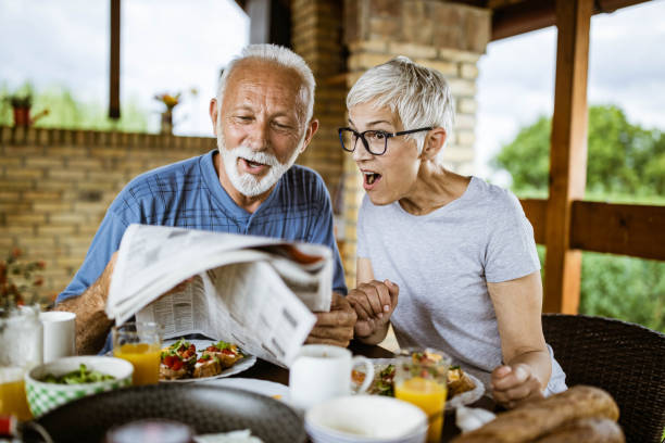 istock Surprised senior couple reading newspapers during breakfast on a terrace. 1434923594