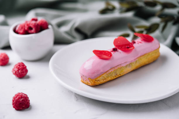 delicious eclairs with pink raspberry glaze stock photo