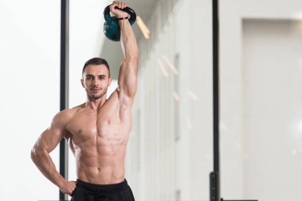 hombre muscular haciendo ejercicio con kettle-bell - kettle bell activity aerobics athlete fotografías e imágenes de stock