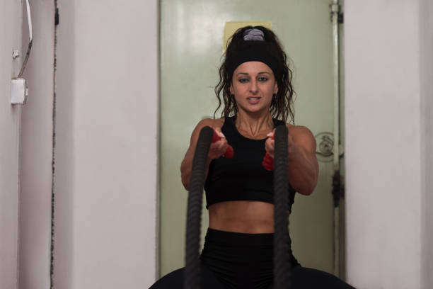 Battling Ropes Young Woman At Gym Workout Exercise
