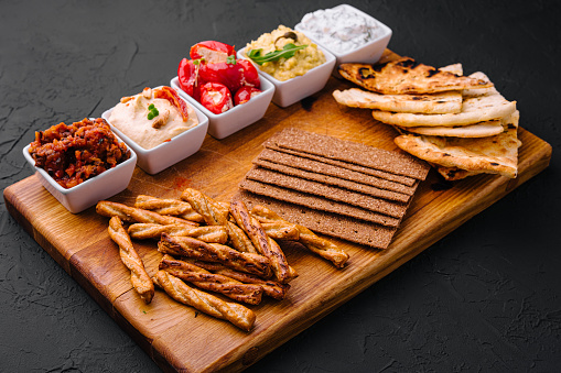 Tasty Assorted Dips on wooden tray