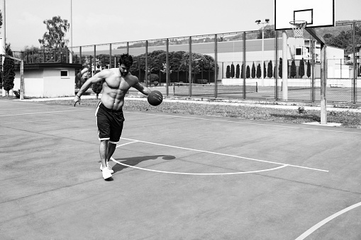 05-07-2016 Paris. A moment in  basketball  match in Paris: young people with white and black skin are playing - a blurry image, but the leg of the main player is in focus, so some art photo. Black and white stylized