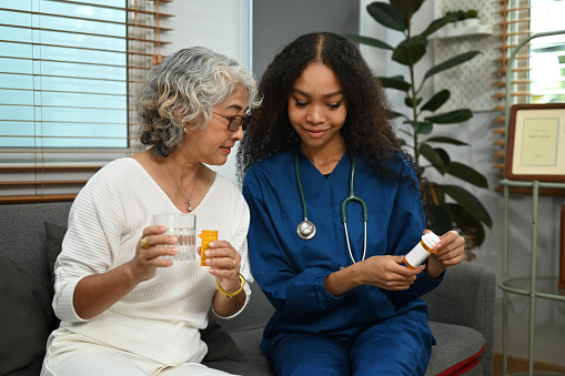 Practitioner nurse explaining medicine dosage to senior patient. Elderly healthcare and Home health care service concept.