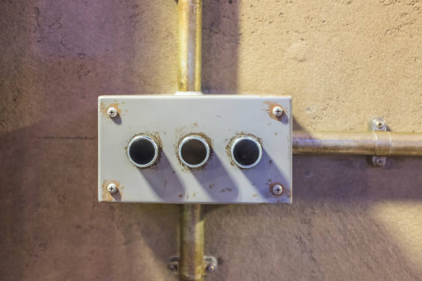 Box with three black buttons mounted laterally on the wall