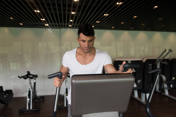istock Healthy Man Doing Aerobics Elliptical Walker In Gym 1434932062