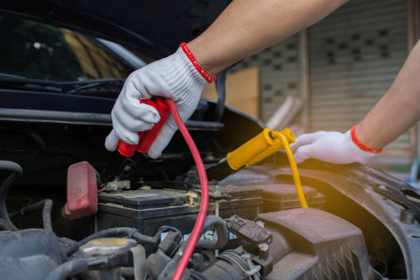 as mãos dos técnicos usam cabos de carregamento para baterias para carros. o conceito de fixar baterias para ligar um carro quebrado. - energy booster - fotografias e filmes do acervo