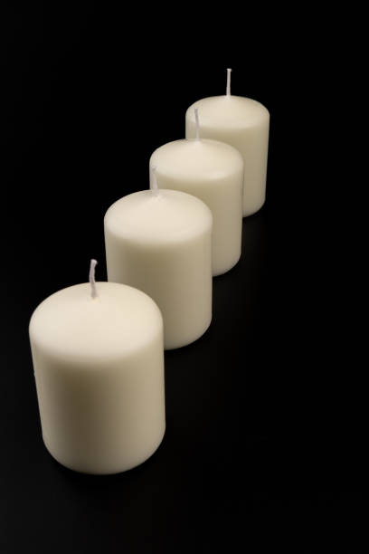 istock White candles on dark background. Close-up, copy space. 1434937926