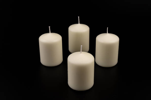 istock White candles on dark background. Close-up, copy space. 1434937928