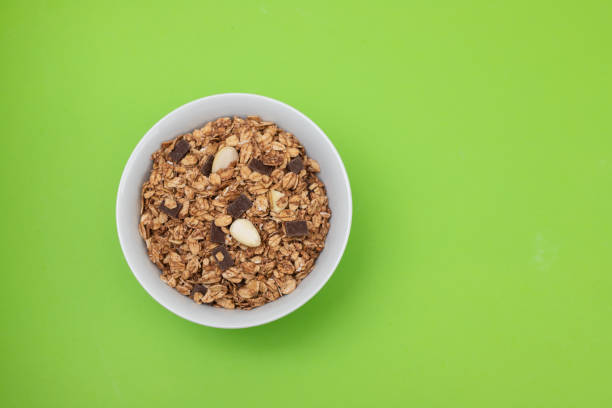 muesli with nuts and chocolate in th bowl on green