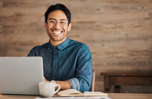 Asian businessman, laptop or notebook in home office, remote working or creative startup with innovation vision, motivation or success mindset. Portrait, smile or happy designer with email technology