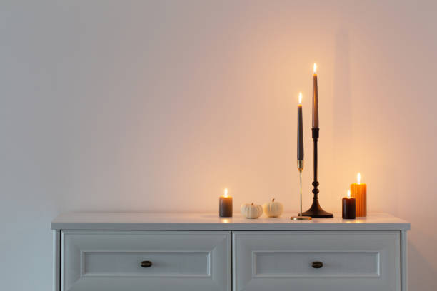 istock burning candles on white wooden shelf in white interior 1434946105