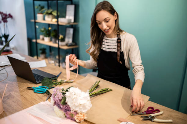 istock Young cheerful florist making bouquet 1434946374