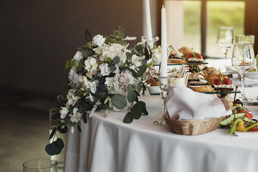 Amazing wedding table decoration with flowers on  tables with plates and food