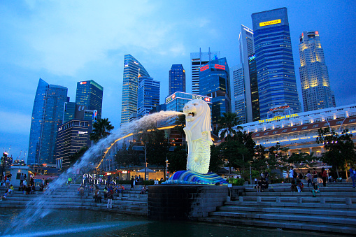 Singapore, Feb 23, 2015. Merlion Park with its iconic lion statue fountain immortalized at dusk. One of the favorite tourist destinations.