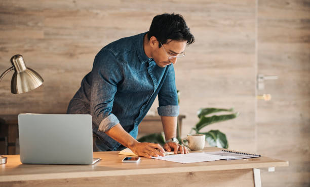 istock Idea, documents and business man thinking and planning in an office with a laptop, creative, innovation and inspiration. Motivation, goal and asian corporate worker doing paperwork and finance 1434947684
