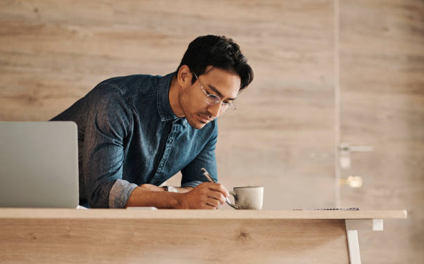 Coffee, writing and startup entrepreneur with laptop writing, brainstorming idea or planning website marketing strategy. Thinking, focus and business man, planner or remote worker advertising mockup