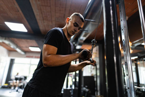 istock One man,  fit man training on exercise machine in gym alone 1434950885