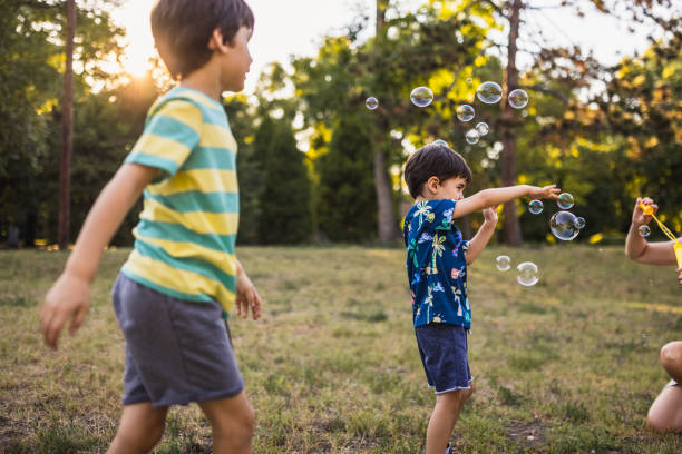 istock Mother and her two sons enjoying blowing bubbles together 1434951919