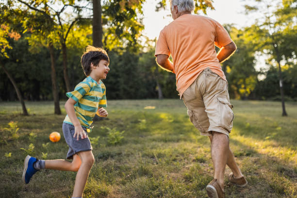 istock Grandfather playing with his grandson in a public park 1434951973