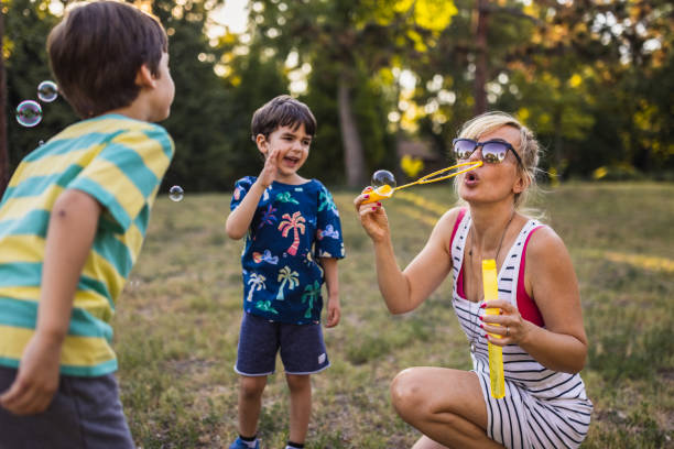 istock Mother and her two sons enjoying blowing bubbles together 1434952014
