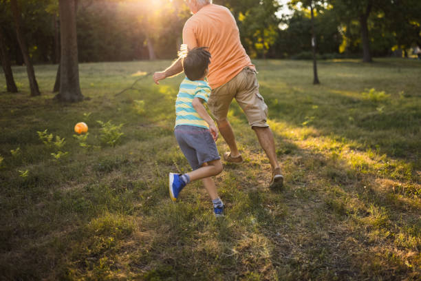 istock Grandfather playing with his grandson in a public park 1434952037