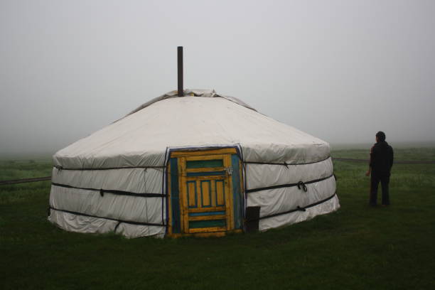 Nomadic tent and a woman in the mist of the tranquil meadow, Khuvsgul, Mongolia. stock photo