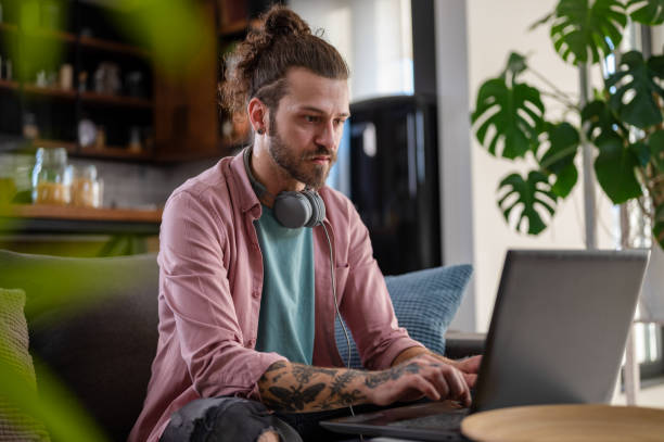istock A young man with a sleeve tattoo working on a laptop computer concentrated on his job. Tattooed young freelancer working on a new startup project 1434955362