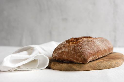 Rye bread on a wooden board on a white tablecloth background