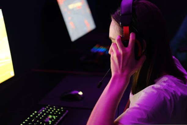 istock Young woman putting on headphones for playing online 1434957430