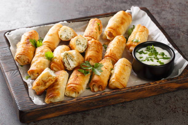 Borek is a Turkish pastry with savory filling with cheese and spinach closeup on the wooden board. Horizontal stock photo