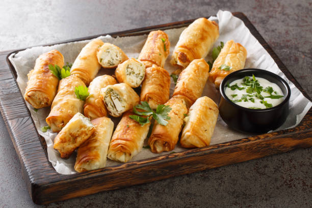 borek is a turkish pastry with savory filling with cheese and spinach closeup on the wooden board. horizontal - cigarette wrapping imagens e fotografias de stock