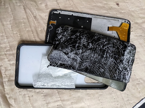 Fragment of a smartphone that breaks into three parts. That is the screen, main board and back cover.