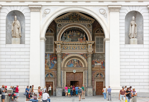 Aosta, Italy - August 17, 2022: Facade of the Aosta cathedral crowded with visitors