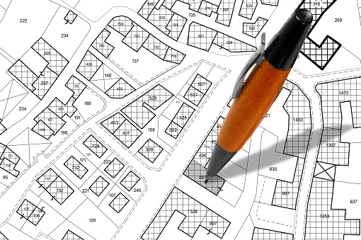 Imaginary cadastral map with buildings, land parcel and vacant plot - land and property registry and real estate property concept illustration with pen