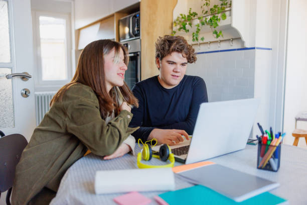 istock Teenage girl and boy doing homework on dedicated platform, using laptop 1434969330