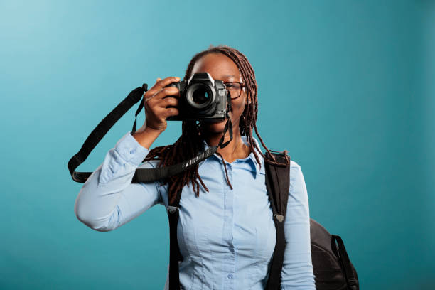 istock Confident and creative photographer taking pictures while enjoying leisure time on blue background. 1434970507