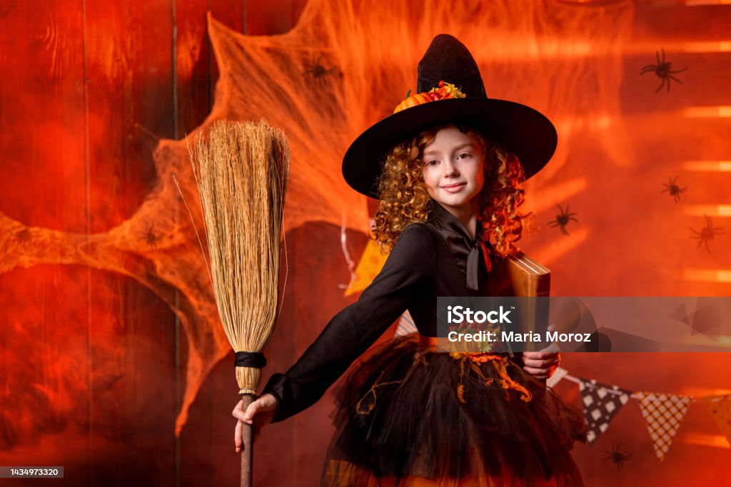 Foto de Feliz Dia Das Bruxas Uma Bruxa Alegre E Fofa Com Livro De Feitiços  E Vassoura e mais fotos de stock de 8-9 Anos - iStock